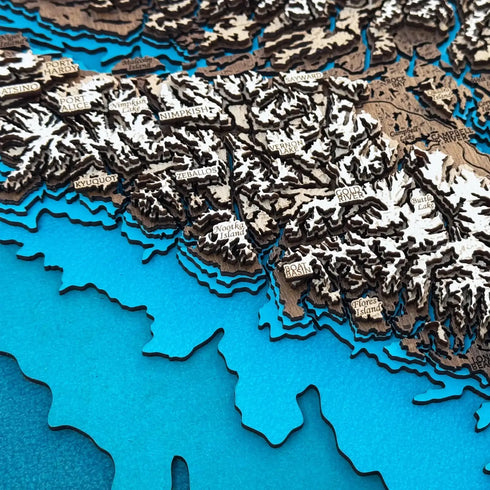 Close-up of Vancouver Island wooden map showing towns, lakes, and mountain engravings
