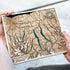 Hand holding detailed laser-cut wooden map of Finger Lakes region