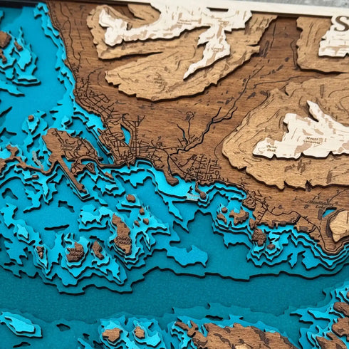 Close up of Sitka Alaska wooden map highlighting engraved mountains and shoreline